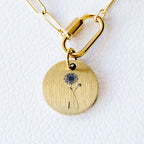 Gold necklace with a round pendant on a white background