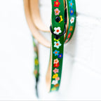 Green dog lead with floral patterns on a white background