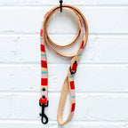 Leash holder with palm tree design holding a colorful dog leash on a white wooden surface