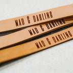 Three leather straps with 'MAD & DARLING' engraving on a light background